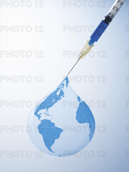 Drop from a syringe forming a globe