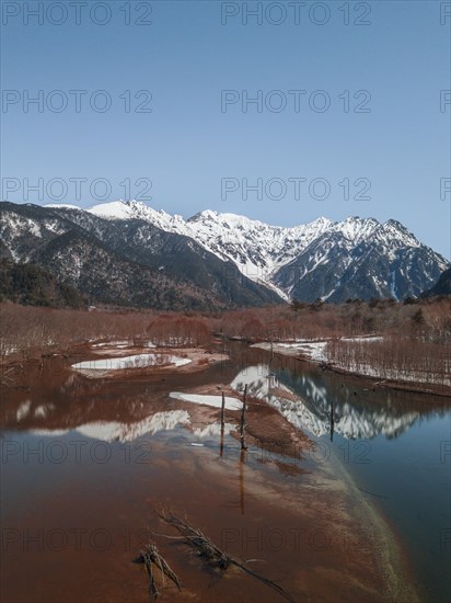 Snow-covered Japanese Alps reflected in Lake Taisho Pond