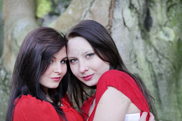 Two sisters in front of an old tree