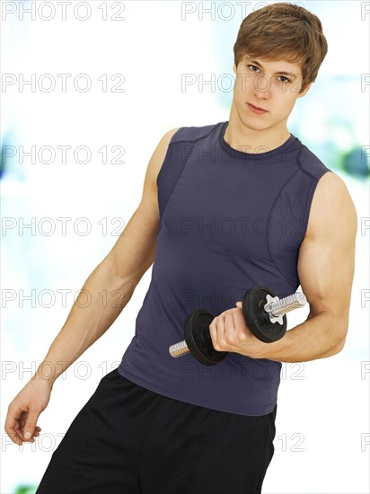 Young man doing strength training with a dumbbell