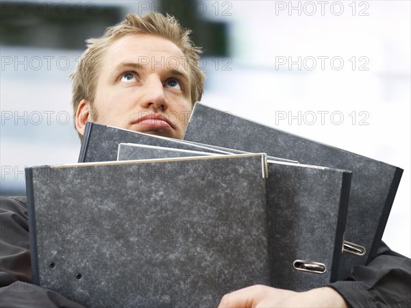 Businessman carrying ring binders