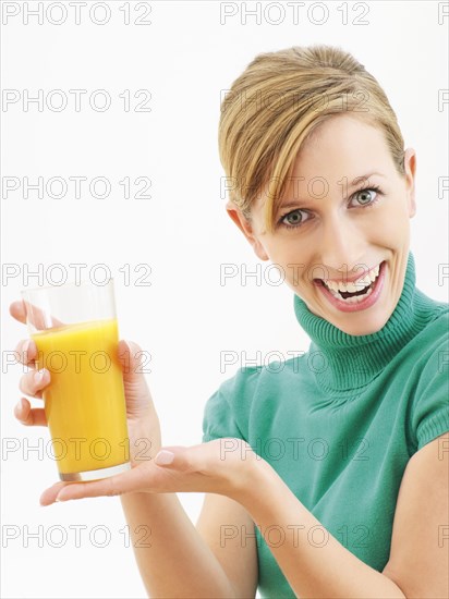 Young woman holding a glass of orange juice