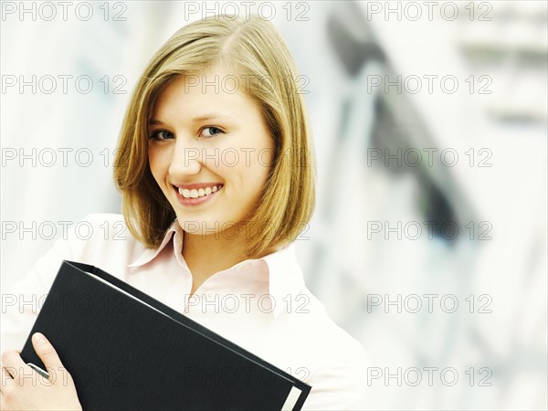 Businesswoman holding a ring binder