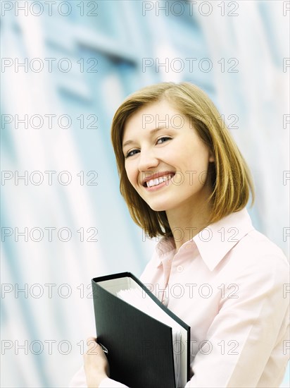 Businesswoman holding a ring binder