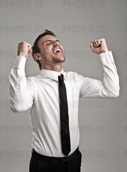 Young man wearing a shirt and a tie cheering