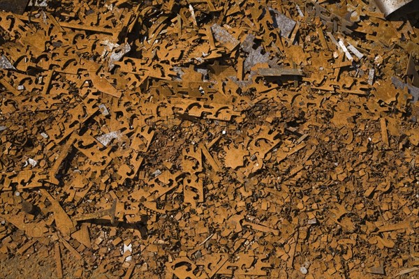 Assorted rusted metal brackets at a scrap metal recycling junkyard