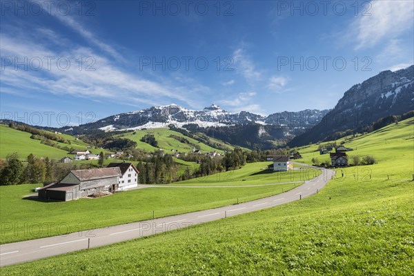 Green pastures in Appenzellerland in front of the snow-capped Appenzell Alps