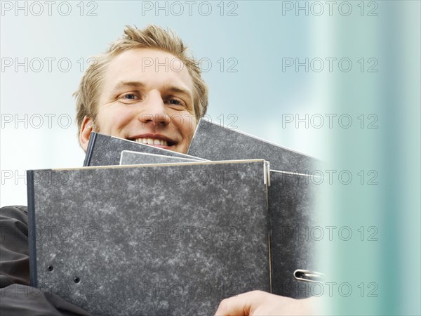 Businessman carrying ring binders