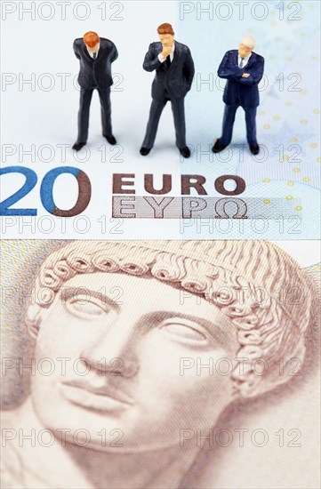 Miniature figurines of businessmen on euro and Greek drachma banknotes