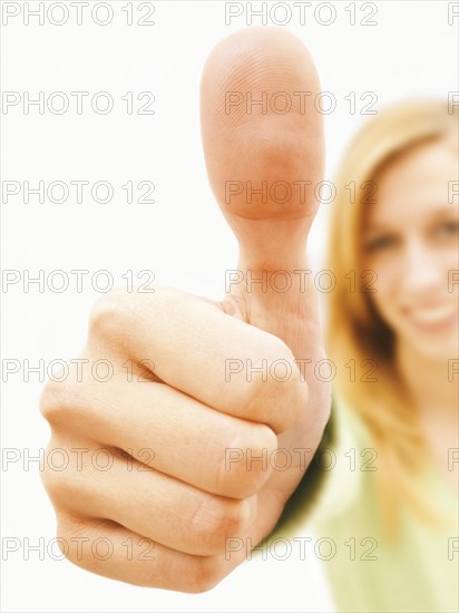 Young woman making a thumbs up gesture