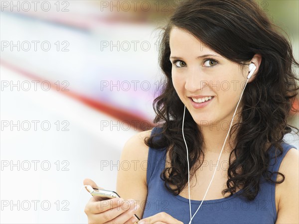 Young woman listening to music at a subway station