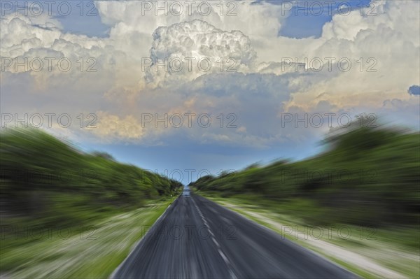 Street with zoom effect and cumulus clouds