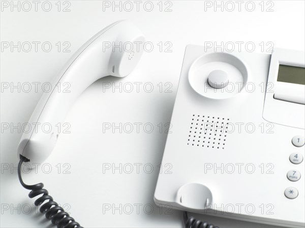 Handset laying beside a telephone