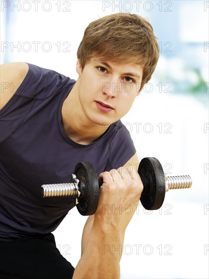 Young man doing strength training with a dumbbell