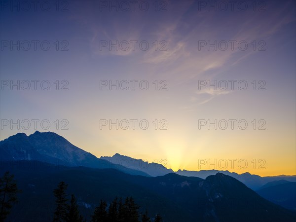 Mountain silhouettes reflected in an artificial mountain lake at sunset