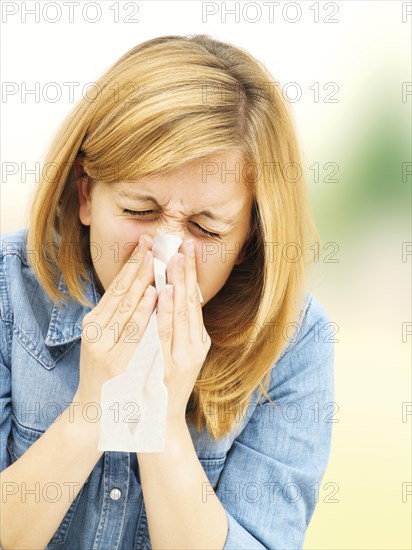 Young woman blowing her nose