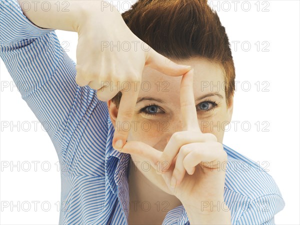 Businesswoman looking through her fingers as a frame