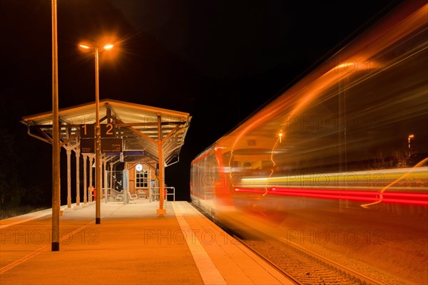 Railway station at night with moving train