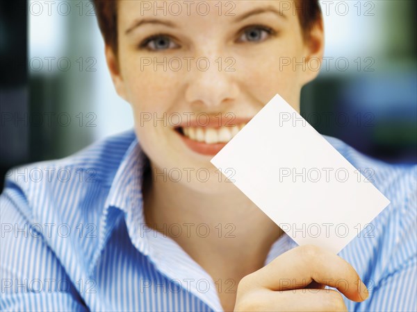 Businesswoman holding a blank business card