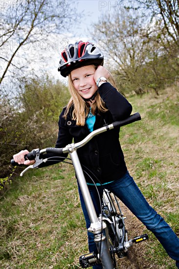 Girl with a cycling helmet and a bike