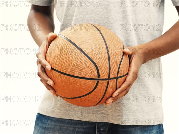Dark skinned-person holding a basketball