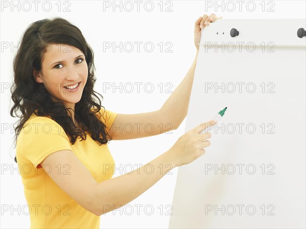 Young businesswoman standing next to a flipchart