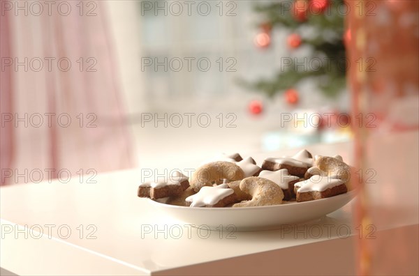 Christmas cookies on a plate in front of a Christmas tree