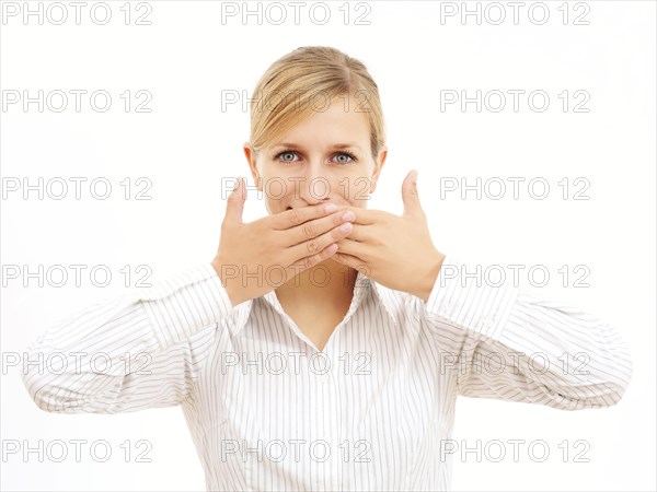 Young woman holding her hands in front of her mouth