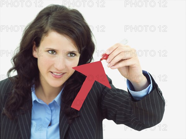 Young businesswoman drawing an arrow pointing upwards