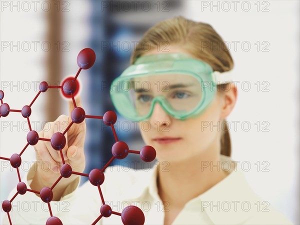 Scientist pointing to a molecule model