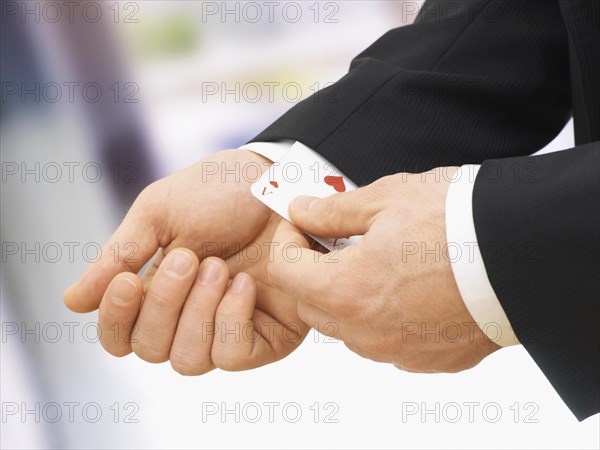 Businessman pulling an ace out of his sleeve