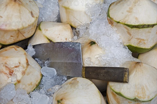 Coconuts for drinking on ice with a Chinese knife