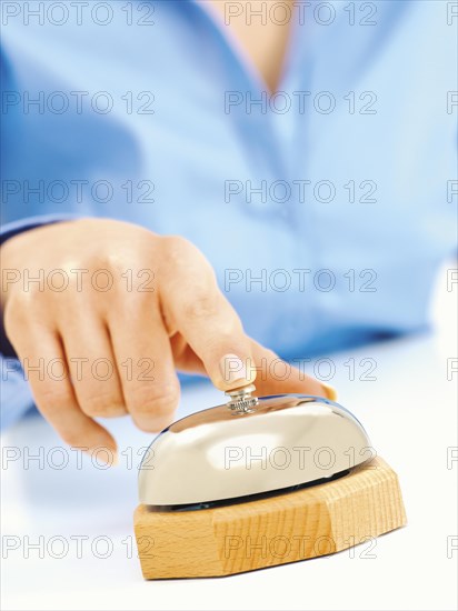 Female hand pressing a porter bell