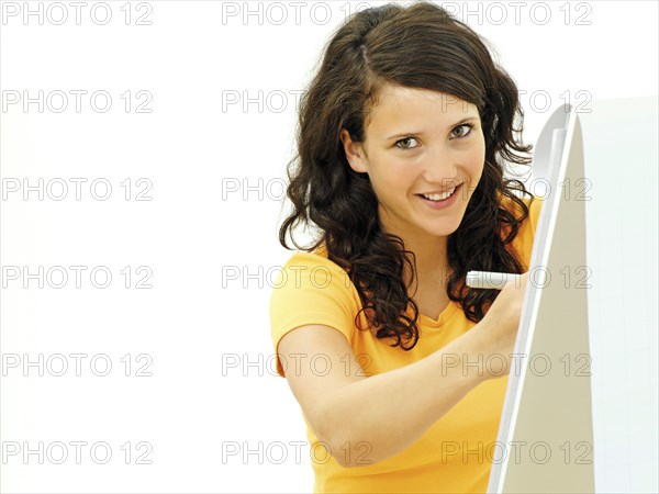 Young businesswoman standing next to a flipchart