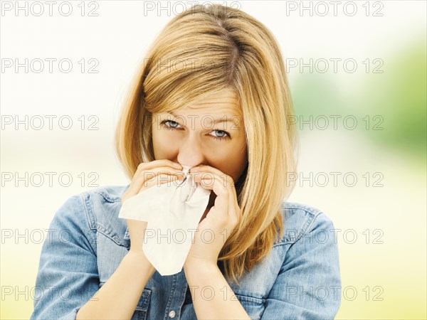 Young woman blowing her nose