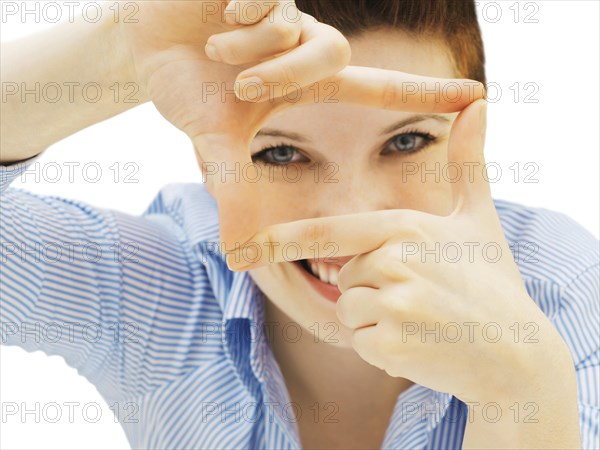 Businesswoman looking through her fingers as a frame
