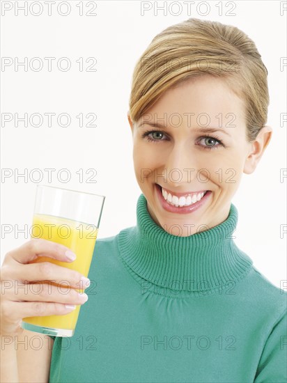 Young woman holding a glass of orange juice