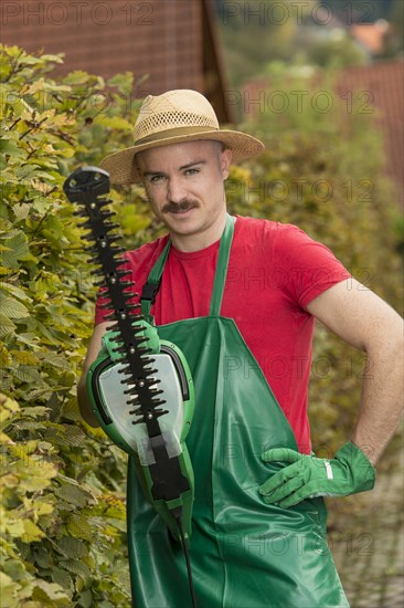 Gardener using a hedge trimmer