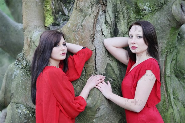 Two sisters in front of an old tree