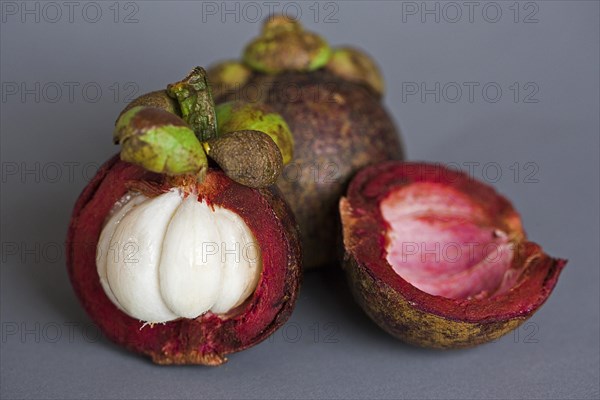 A halved and a whole Mangosteen (Garcinia mangostana)