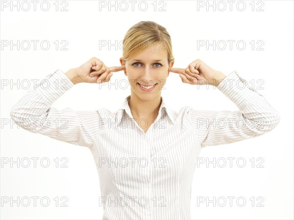 Young woman holding her fingers in her ears