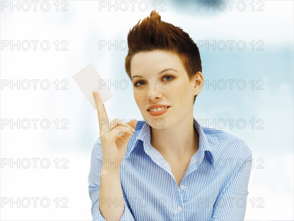 Businesswoman with a punk hairstyle holding a blank business card