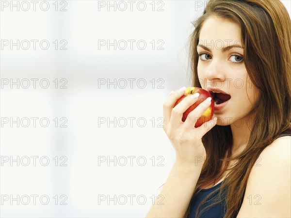 Young woman eating an apple
