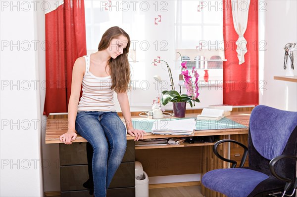 Teenage girl in her room at home
