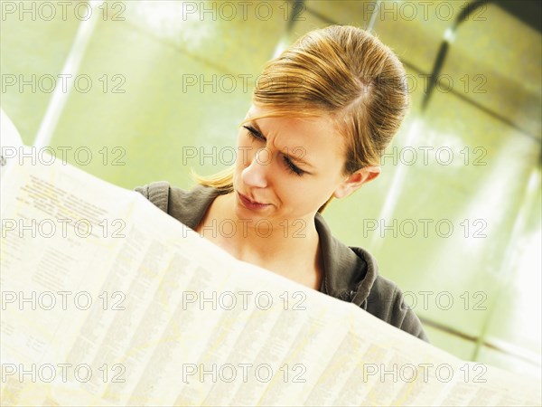 Young woman studying a city map at a U-Bahn metro station