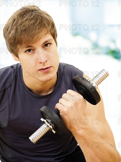 Young man doing strength training with a dumbbell