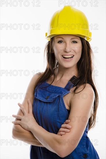 Woman wearing blue overalls and a hardhat