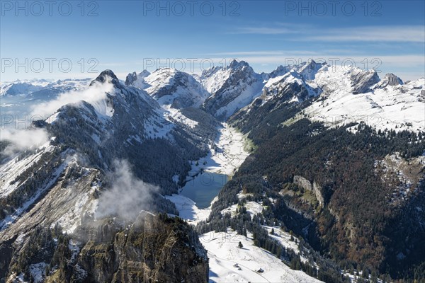 The snow-covered Appenzell Alps and lake Saemtisersee