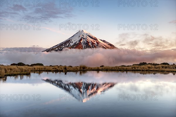 Water reflection in Pouakai Tarn Mountain Lake at sunset