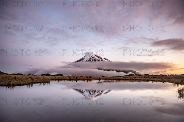 Water reflection in Pouakai Tarn Mountain Lake at sunset